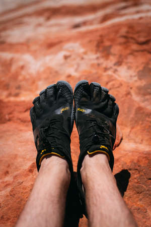 Valley of Fire, Nevada, USA - October 6, 2019: Detail on a person wearing Vibram Five Finger hiking shoes at Fire wave, Valley of Fire national park,のeditorial素材