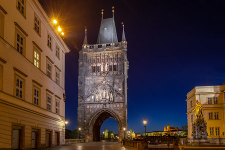 Empty Charles Bridge in the center of Prague during first wave of Covid-19 pandemy in the night with blue sky and yellow lightsのeditorial素材