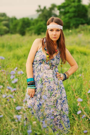 Beautiful hippy woman in a dress on the meadow in summer dayの写真素材