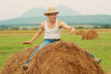 farmer as the cowboy riding on a haystackの写真素材