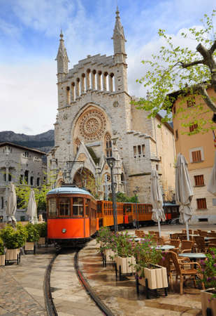Old tram in the downtown of Soller in front of medieval gothic cathedral with huge rose window,...