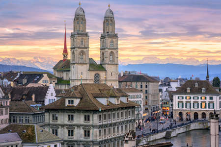 Zurich city center and cathedral towers with snow covered Alps mountains in background on sunset, Switzerlandの写真素材