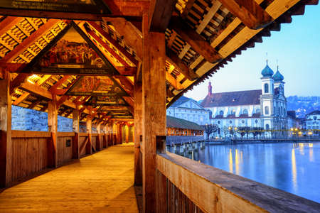 Historical wooden Chapel Bridge decorated with medieval paintings in the old town of Lucerne, Switzerlandの写真素材