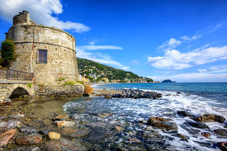 Historical Saracen tower on mediterranean beach in Alassio, popular resort town on italian Riviera, Liguria, Italyの写真素材