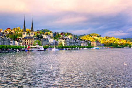 Skyline of Lucerne town with towers of St. Leodegar church and luxury hotels on Lake Lucerne, Switzerland, on sunsetの写真素材