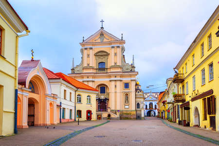 Pedestrian street in the old town of Vilnius, capital of Lithuania, with Gates of Dawn, orthodox monastery and catholic churchの写真素材