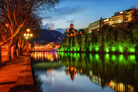 Tbilisi Old Town and Metekhi Church on a cliff over Kura river at late evening light, Georgia