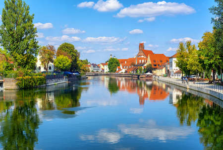 Landshut gothic medieval Old Town, Bavaria, Germany, reflecting in Isar river on a summer day with...