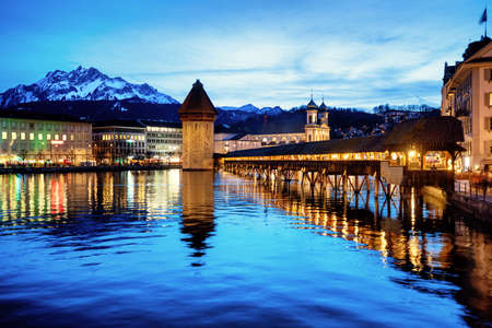 Lucerne, Switzerland, the wooden Chapel bridge, the Old town, Reuss river and Mount Pilatus in blue evening lightの写真素材