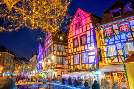 Colmar, France - November 23 2019: Traditional illuminated Christmas market on a street of Old town in Colmar, Alsace. Christmas market in Colmar is one of the most beautiful and visited in Europe.のeditorial素材