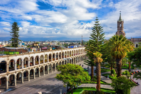 Areqiupa, Peru, view of the city's main square Plaza de Armas, the colonial buildings with archways and the snowcapped peak of the Chachani volcano in the Andes mountainsの写真素材