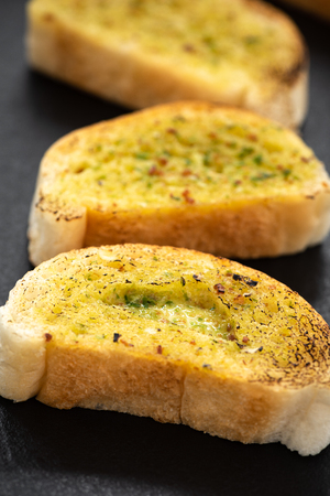 Crunchy garlic bread on dark backgroundの写真素材