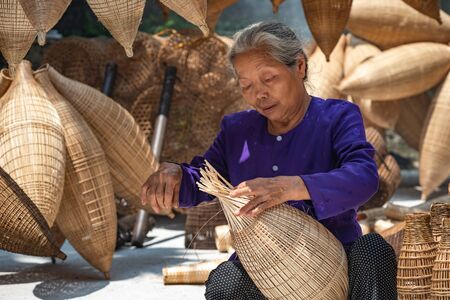 VIETNAM, July 16, 2018 Old Vietnamese craftsman making the traditional bamboo fish trap or weave at the old traditional house in Thu sy trade village, Hung Yen, Vietnam, traditionalのeditorial素材