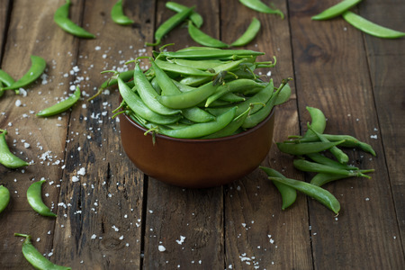 Green pea in bowl on rustic wooden backgroundの写真素材