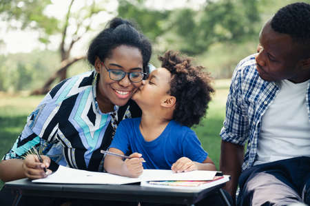 Happy black people family with educate homework son in garden