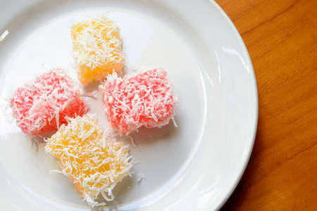 Thai dessert steam-minced cassava with shredded coconut on white dishの写真素材