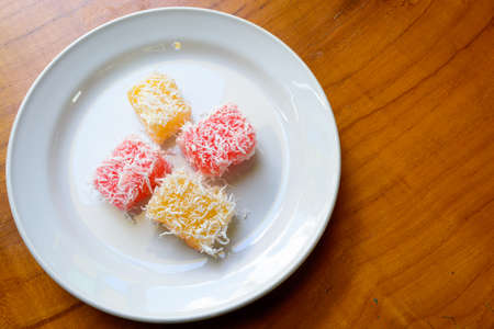 Thai dessert steam-minced cassava with shredded coconut on white dishの写真素材