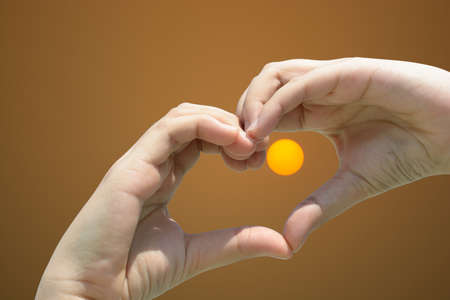 Girl hand in heart form love on sunset skyの写真素材