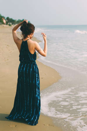 Lady in dark blue dress on the beachの写真素材