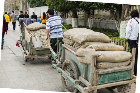 XIAMEN - MARCH 4:  workers transport goods at Gulangyu Island on March 4, 2014 in Xiamen, China. Although Xiamen is China's no.8 biggest harbor there is still a lot of physical labor activity.のeditorial素材