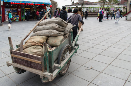 XIAMEN - MARCH 4:  workers transport goods at Gulangyu Island on March 4, 2014 in Xiamen, China. Although Xiamen is China's no.8 biggest harbor there is still a lot of physical labor activity.のeditorial素材