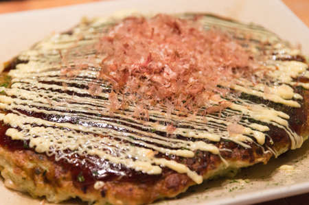 Okonomiyaki is a Japanese style meat and vegetable pancake.の写真素材