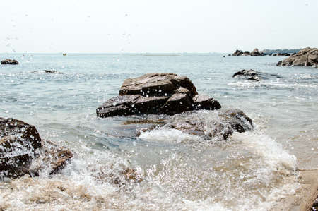 A Rock formation with splashing seawater on a beach, Lamma Island Hongkongの写真素材