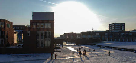 Typical modern dutch scene of people ice skating in Amsterdam Ijburg.の写真素材
