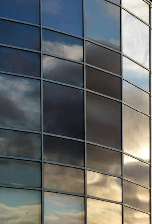 Sky is reflecting in glass of office building.の写真素材