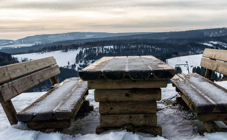picnic table and bench in winterlandscapeの写真素材