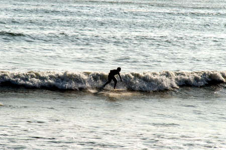 Backlight Silhouette Surfer in the Ocean at Sunset
