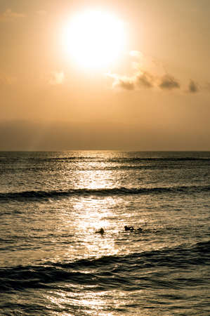 Backlight Silhouette Surfer in the Ocean at Sunsetの写真素材