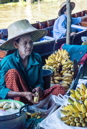RATCHABURI THAILAND  JUN 19: A woman makes Thai food at Damnoen Saduak floating market on June 19 2015 in Ratchaburi Thailand. Its popular for traditional style Thai food and old Thai culture.のeditorial素材