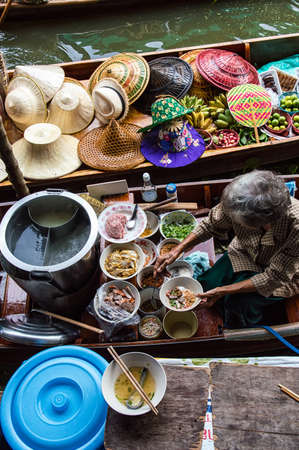 Food vendor at the Damnoen Saduak Floating Market preparing Thai style food Thailand.の写真素材