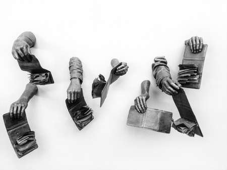 sculpture of multiple hands holding out empty wallets from a wallの写真素材
