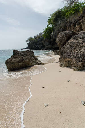 the water laps at the white sand beach on a tropical island.の写真素材