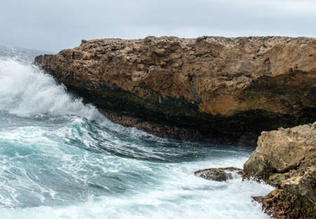 Splashing waves at a rough and rocky coastline at Boka Pistol. This is the northern coastline at Shete Boka national park at Curacao, Dutch Antilles.の写真素材