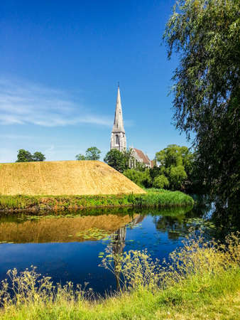 St. Alban's Church is located in Churchill Park, or Parken if you're Danish, and rises over the canal and levee of the parkの写真素材