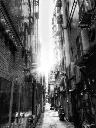 Black and White shot of an small Alley in Hong Kong with sun bursting thoughの写真素材