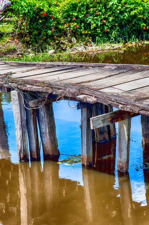 Closeup detail of a rustic old wooden footbridge with weathered planksの写真素材