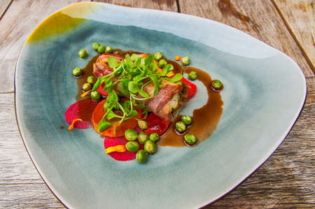 Flounder in a pancetta coat with green peasの写真素材