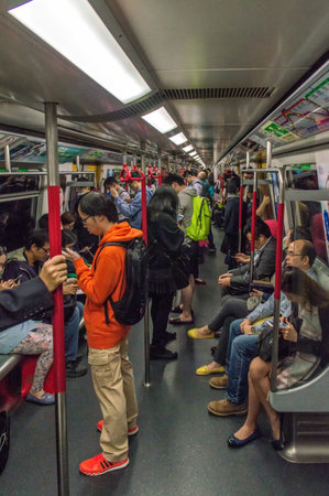 Hong Kong, China - November 30, 2015: Businessman with smartphone inside subway train in Hong Kong.With over 150 stations, four million people use it every week. This very efficient system created in 1979 has relieved the unsustainable traffic growth in oのeditorial素材