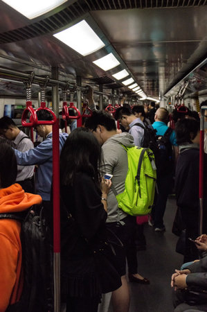 Hong Kong, China - November 30, 2015: Businessman with smartphone inside subway train in Hong Kong.With over 150 stations, four million people use it every week. This very efficient system created in 1979 has relieved the unsustainable traffic growth in oのeditorial素材