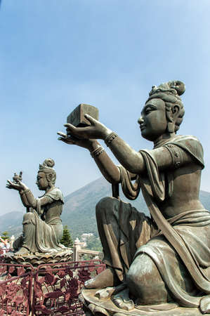 Female statue offering a gift to the Big Buddha at Po Lin monastery, Lantau Island, Hong Kong.の写真素材
