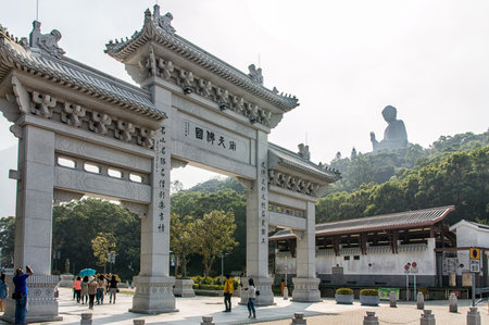 Tourists sightseeing the Po Lin Monastery, surrounded by the giant Tian Tan Buddha statue, located on Ngong Ping Plateau on Lantau Island, Hong Kong.
The main temple houses three bronze statues of the Buddha â representing his past, present and future lのeditorial素材