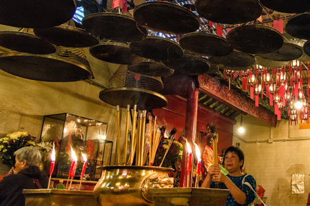 The interior of the Man Mo Temple, Hong Kong, with incense offerings and coils suspended from the ceiling.のeditorial素材