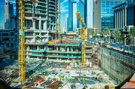 Dubai, United Arab Emirates - March 25, 2015: Massive buiding site with a lot of building machinery and many foreign construction workers in Dubai near by Burj Khalifa. Picture showing economical growth of UAE.のeditorial素材