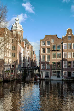 City view of Amsterdam canals and typical houses with in the background the Nicolaaskerk.の写真素材