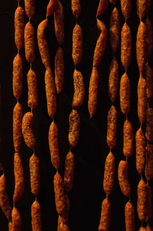 German sausages hanging against a black backgroundの写真素材