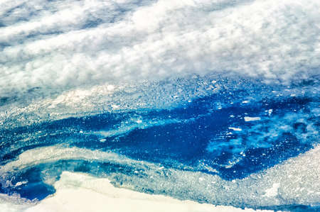 Aerial Shot of the Barents Sea with chunks of ice breaking of the main land